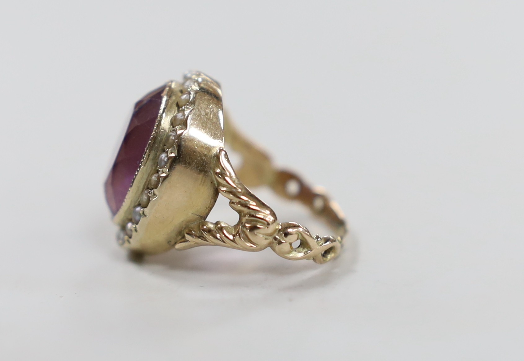A Victorian style yellow metal, amethyst and seed pearl set oval dress ring, size N/O, gross weight 6.3 grams.